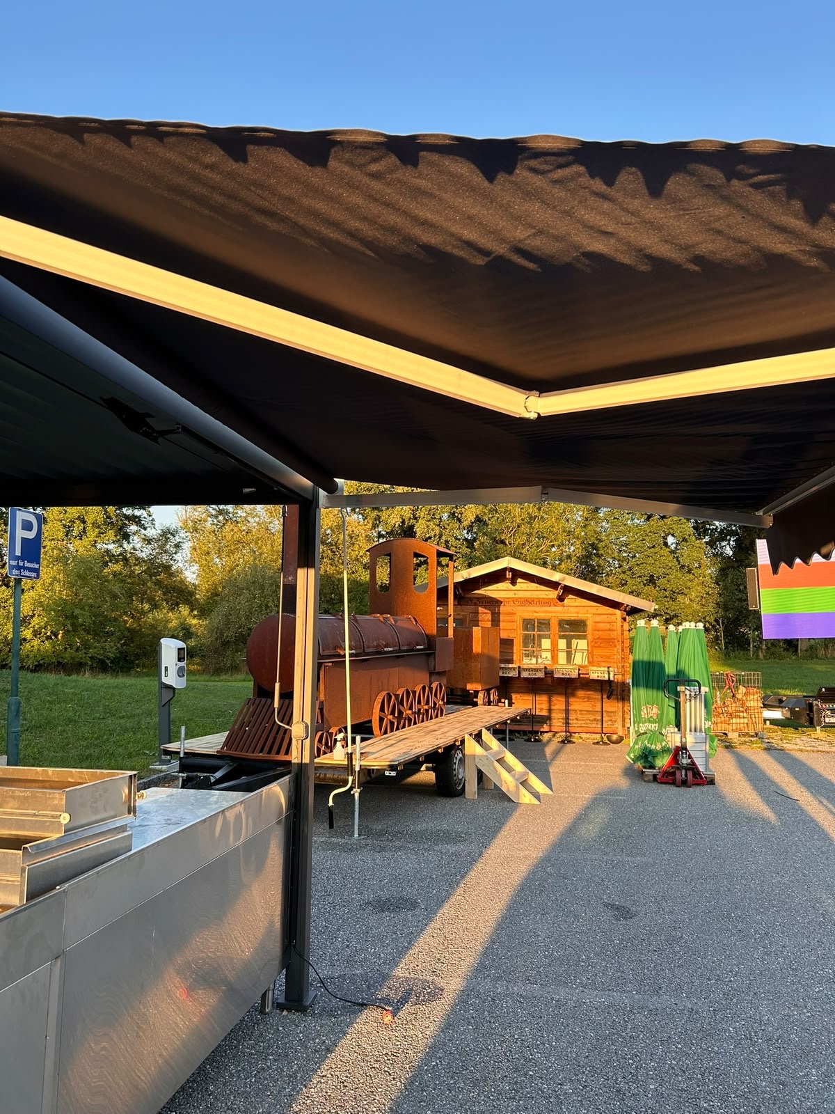 Unsere Grilllok mit Anhänger und Holzplattform in der Abendsonne